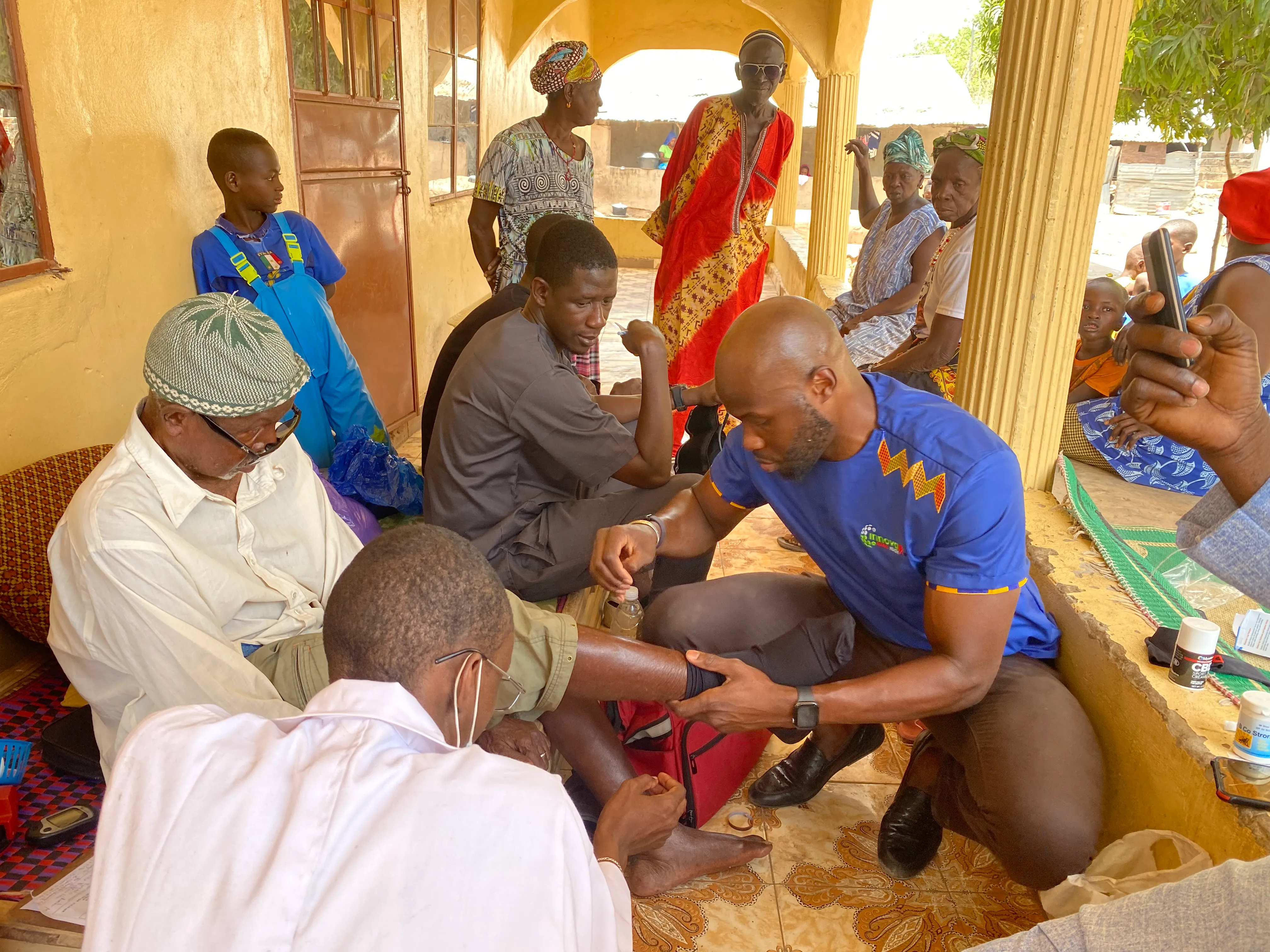 Dr. Ismail D Badjie examining a patient at a community-health visit in The Gambia